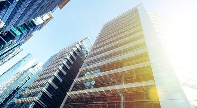 Common modern business skyscrapers, high-rise buildings, architecture raising to the sky, sun. Concepts of financial, economics, future etc.