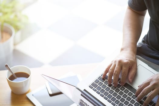 Laptop in businessman hand with digital tablet,smartphone and coffee .