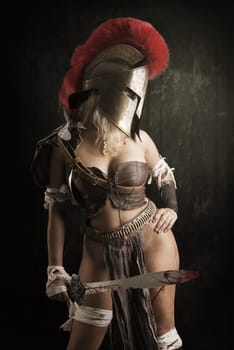 Ancient woman warrior or Gladiator posing in a dark background