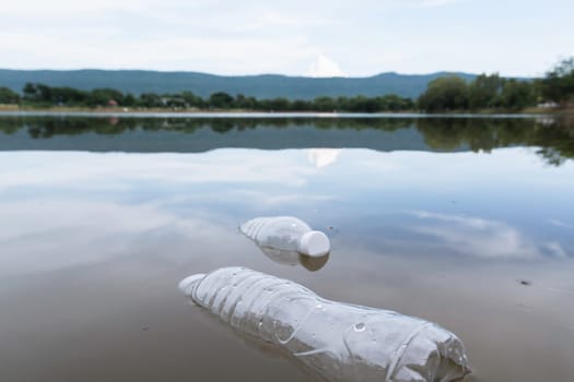 Plastic water bottles pollution in the river. Plastic trash in water. Environmental pollution concept.