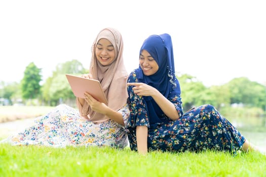 Young adult teenager Muslim Islamic Thai Asian women using smartphones and tablet in social media.
