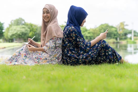 Young adult teenager Muslim Islamic Thai Asian women using smartphones and tablet in social media.