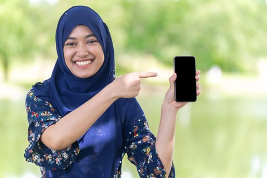 Portrait of good-looking Happy young teenager Muslim islamic asian university girl hold mobile phone
