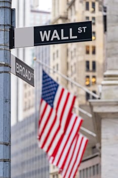 Wall street sign with New York Stock Exchange background New York City, New York, USA.