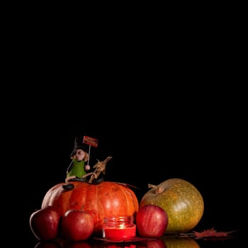 Halloween still life with pumpkin, autumn leaves, candle and witch on a black background. Halloween background
