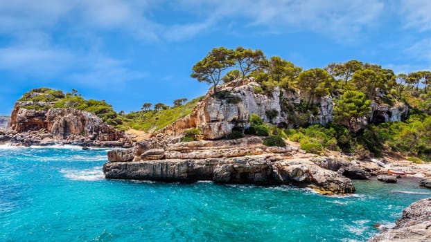 Panorama of beautiful beach and bay with cliffs, trees and turquoise sea water, Cala sAlmunia, Santanyi, Mallorca island, Spain