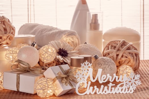 Spa still life with cosmetic creams, towel, gift boxes and Christmas ornaments standing on bamboo mat. Christmas Healthy lifestyle, body care, Spa treatment and relaxation concept