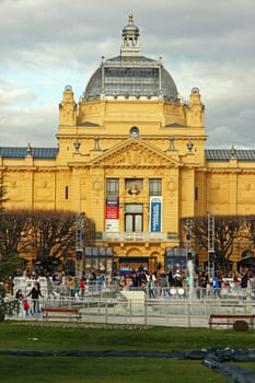 ZAGREB, CROATIA – JANUARY 6, 2018: Ice skating park in winter on King Tomislav square, located near the Art Pavilion, with visitors skating around the fountain, Zagreb, Croatia