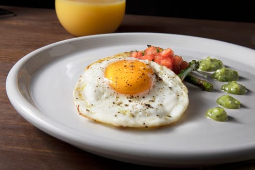 Fried egg with hashbrowns, asparagus, tomatoes and avocado sauce.