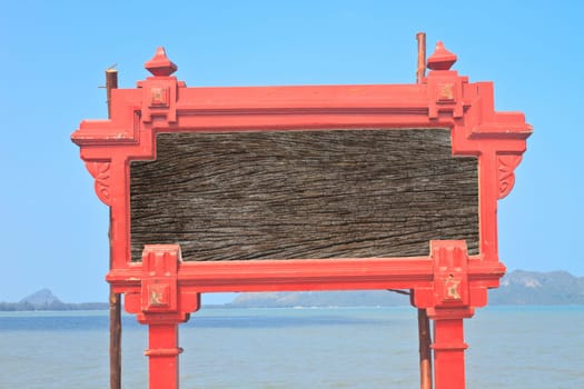 an image of a signpost situated against a wall at a sunny beach