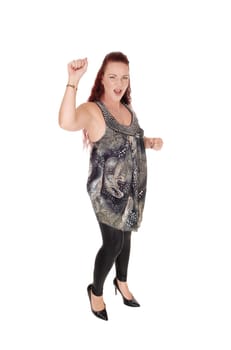 A upset woman standing in a dress and black tights raising her hand.with a fist shouting, isolated for white background.