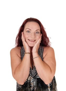 A lovely beautiful woman in a evening dress standing in the studio.with her hands on her face, smiling, isolated for white background.