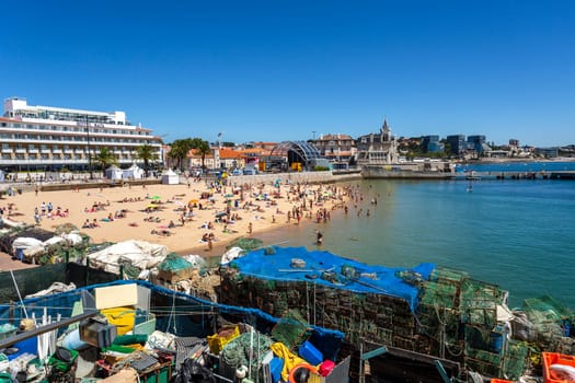 View of the crowded pretty little beach named Praia do Pescador along the famous fishing traps of the Cascais Bay, nearby Lisbon, Portugal