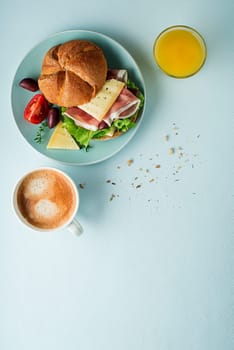 Breakfast served with coffee, juice, sandwich with ham, cheese, tomato and lettuce. Continental delicious healthy breakfast table