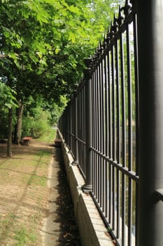 path along high steel  fence going straight into the distance