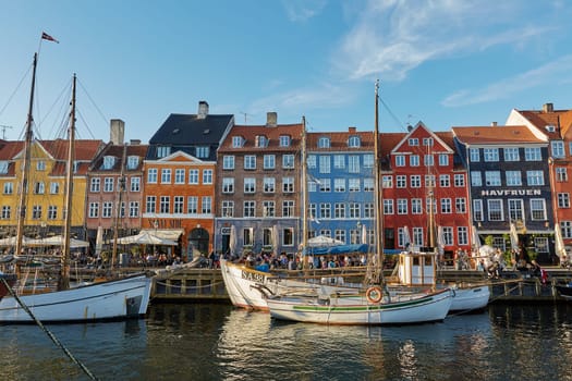 COPENHAGEN, DENMARK - MAY 25, 2017: Colourful facades and restaurants on Nyhavn embankment and old ships along the Nyhavn Canal in Copenhagen, Denmark