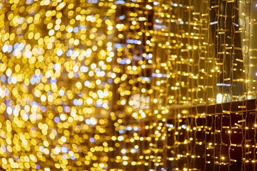 Festive background with LED lights garland. Christmas and New Year background. Blurred bokeh from the lights of a garland.