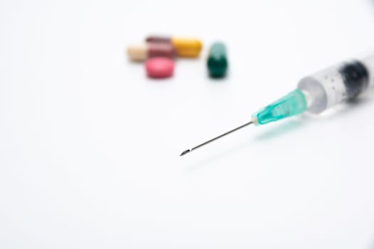 pharmaceuticals antibiotics pills, medicine pills, and capsules and syringe on white background.