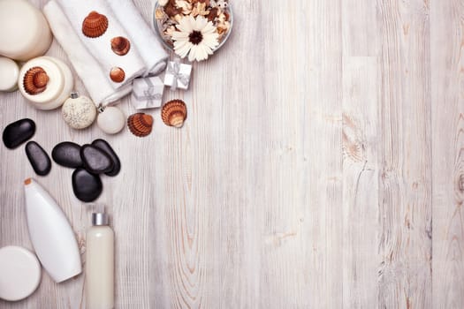Spa still life with cosmetic creams, towel and Christmas ornaments on light wooden background. Top view with copy space. New Year and Christmas Healthy lifestyle, body care, Spa treatment