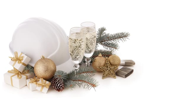 Construction hard hat, fir tree branches, two glasses with champagne, gift boxes and Christmas ornament isolated on a white background. New Year and Christmas construction background