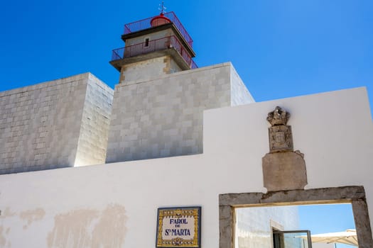 Detail of the top section of the Santa Marta Lighthouse built in 1867, the royal coat of arms and crown and the lighthouse name on a typical Portuguese tiles plate, in Cascais Portugal