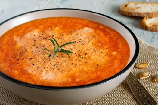 Pumpkin cream soup with cream, crackers and oregano