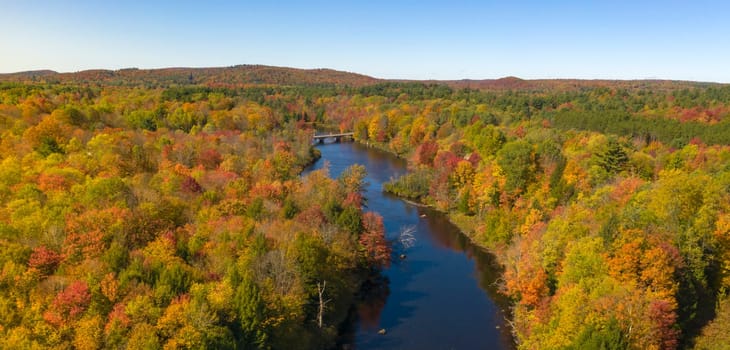 Fall color is more saturated at sunset over the Oswegatche River Adirondack Park Mountains New York