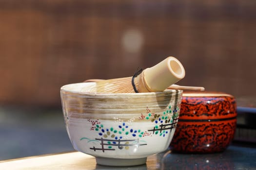Japanese matcha green tea in a ceramic bowl with tea whisk