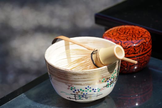Japanese matcha green tea in a ceramic bowl with tea whisk