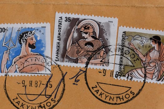 GREECE - CIRCA 1986: Poseidon ancient greek god of the sea Athena goddess of wisdom and Hestia goddess of home and family values mythology illustrations on vintage postage stamps printed and postmarked by the Hellenic Post.