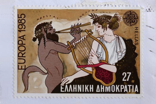 GREECE - CIRCA 1985: Marsyas greek mythology satyr plays aulos double flute on music challenge that cost him his life against Apollo ancient god of music and the arts. Illustration on vintage postage stamp printed by the Hellenic Post.