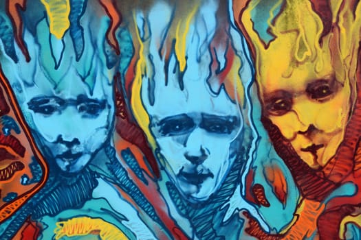 ATHENS, GREECE - APRIL 27, 2015: Abstract graffiti three distorted faces with flames. Colorful urban street art.