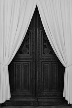 ATHENS, GREECE - APRIL 27, 2015: Antique wooden carved gate and drapes during repairs at the Metropolitan Cathedral of Athens, Greece. Black and white.