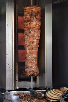 Pork gyros on vertical broiler rotisserie machine and grilled pita souvlaki bread. Traditional greek fast food.