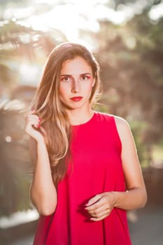 Fashion portrait of a beautiful woman in red dress outdoor