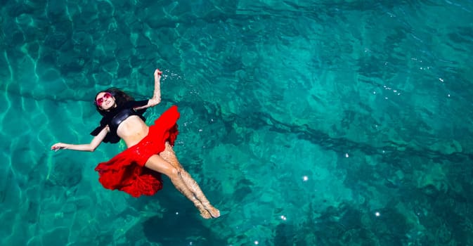 Aerial view of a beautiful woman dancing  in the sea