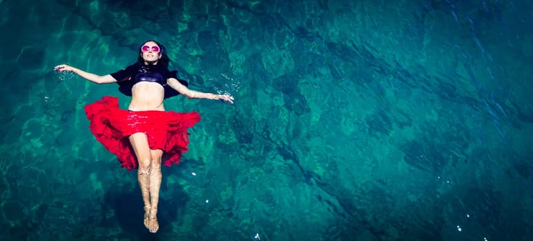 Aerial view of a beautiful woman dancing  in the sea