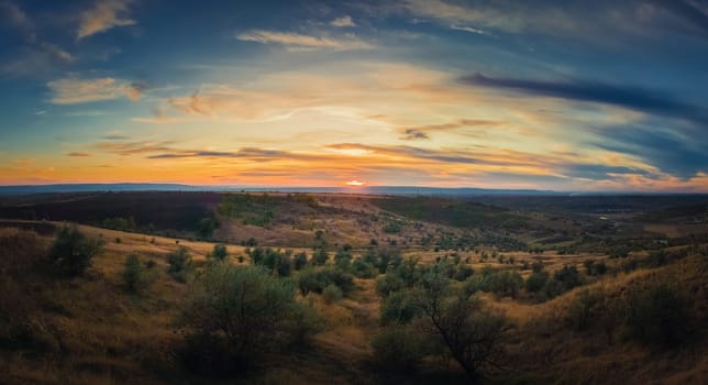 Soft autumn sunset panorama over countryside hills and valley. Beautiful rural landscape, nature scene.