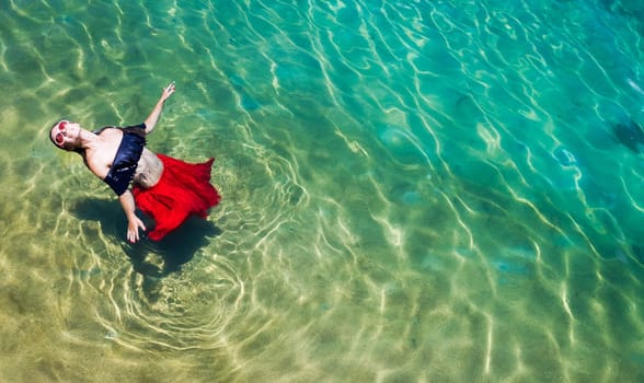 Aerial view of a beautiful woman dancing  in the sea