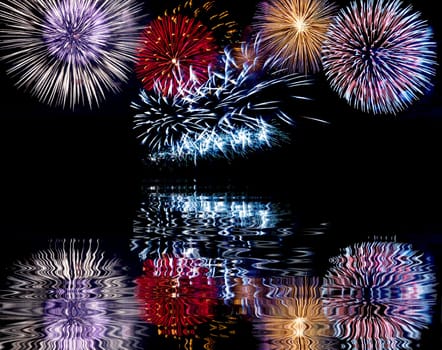 Blue, red and white colorful fireworks with reflection. Holiday celebration.