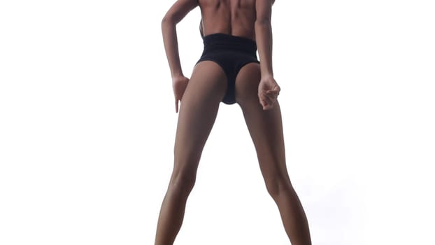 Back view of beautiful woman in black bodysuit posing over white wall background