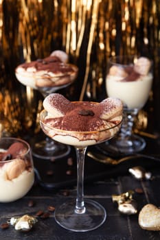 Festive tiramisu dessert in glasses with golden decorations for the holidays