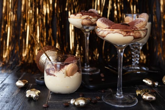 Festive tiramisu dessert in glasses with golden decorations for the holidays