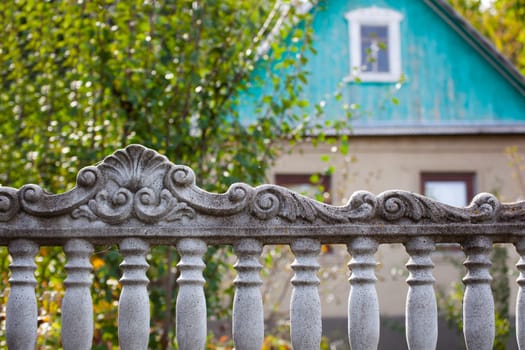 Decorative stone fence in the village on the background of the village house