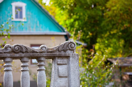 Decorative stone fence in the village on the background of the village house