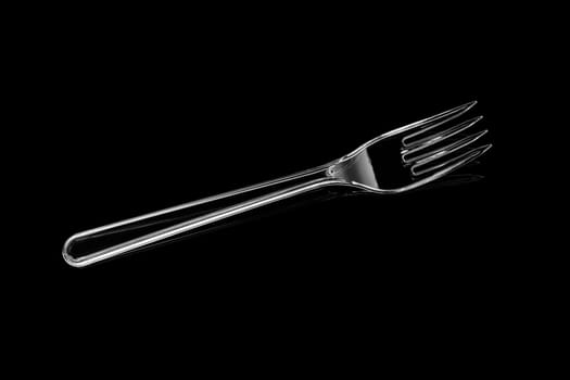 Transparent plastic fork isolated on black background. With clipping path
