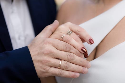 Wedding rings on the hands of the bride and groom close-up
