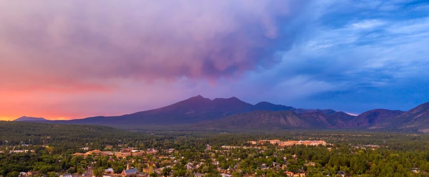 Blue and Orange color swirls around in the clouds at sunset over Flagstaff Arizona