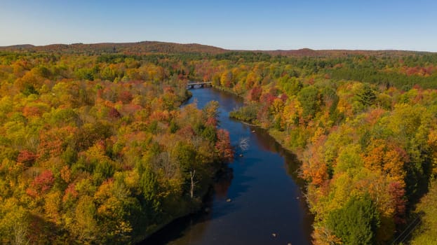 Fall color is more saturated at sunset over the Oswegatche River Adirondack Park Mountains New York