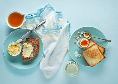 Breakfast served with boiled egg, honey and butter. Delicious good breakfast.